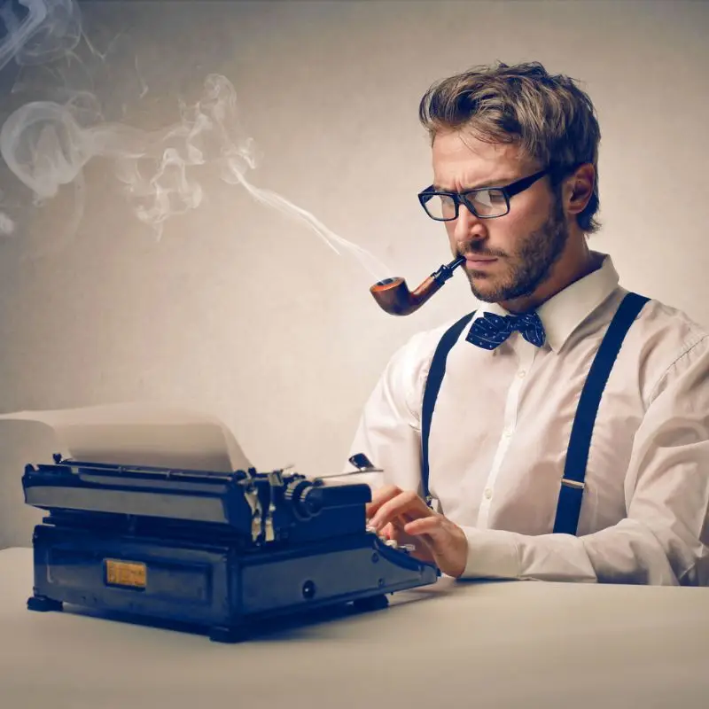 man tyiping a case study on a typewriter, while smoking a pipe