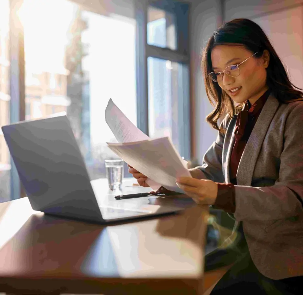 asian-businesswoman-analyzing-reports-while-workin