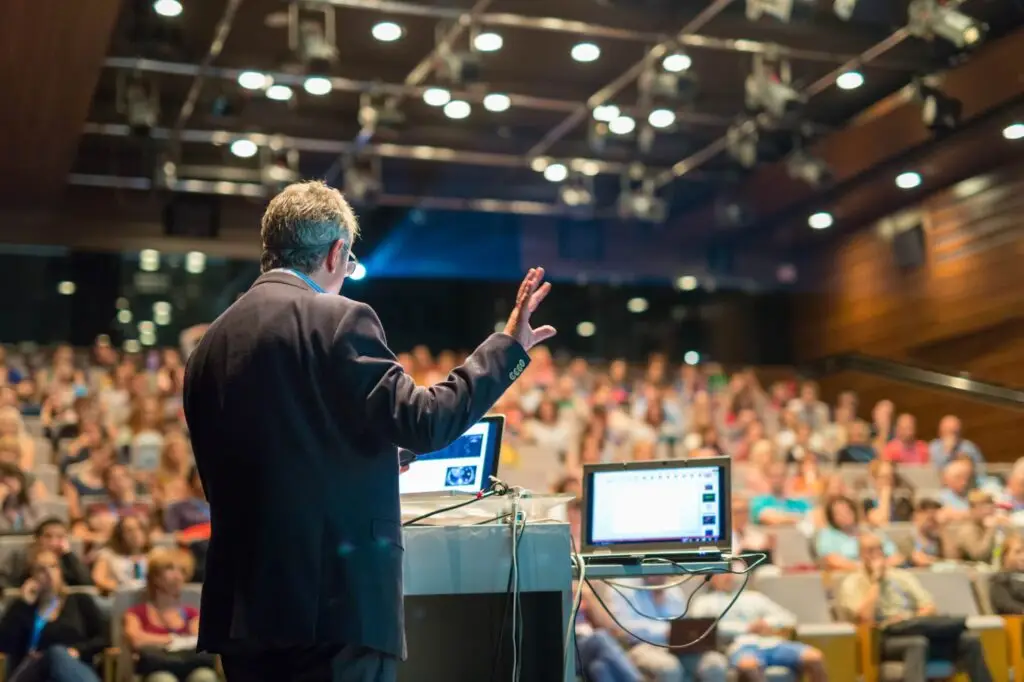 Speaker educating a crowd at a business conference.