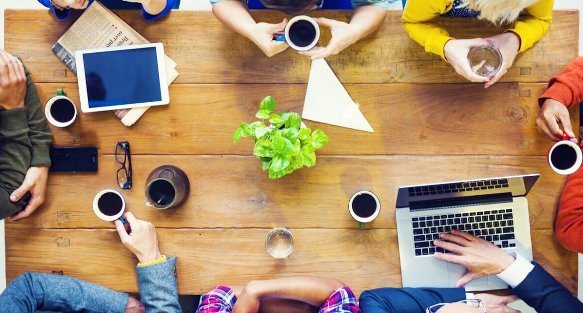 Overhead shot of startup employees at startup discussing business at a table